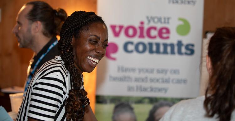 Woman laughing with a Healthwatch banner in the background